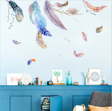 Load image into Gallery viewer, Colorful feather-shaped wall decals applied on a blue wall, with various colors and patterns creating a dynamic and vibrant look.